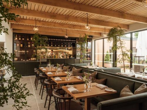 a restaurant with wooden tables and chairs and a bar at The Great Bustard in Durnford
