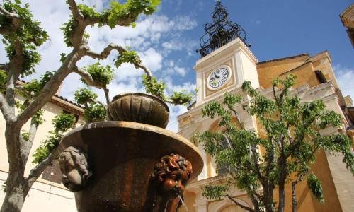 a statue in front of a building with a clock tower at Petit Cocon cosy au cœur du village d'Allauch in Allauch