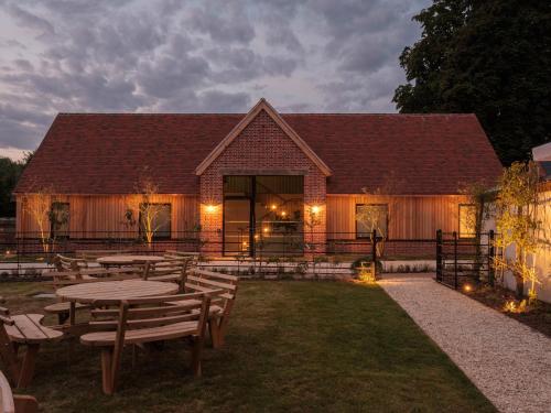 a building with tables and benches in front of it at The Great Bustard in Durnford
