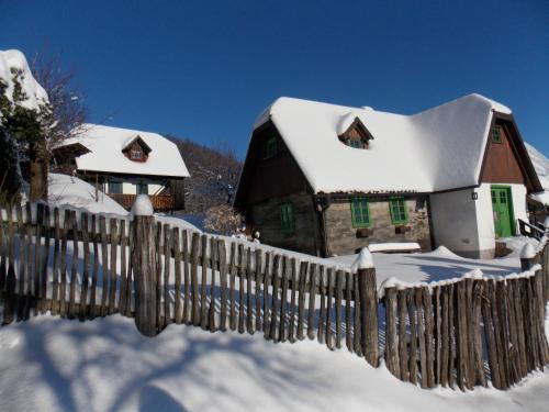 a fence in front of a house covered in snow at APARTMANI Etno kuća pod Okićem in Samobor
