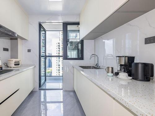 a white kitchen with a sink and a counter top at Annie 2704-only 260 metres from Metro Line 2 Exit C of BeiChun in Kunming