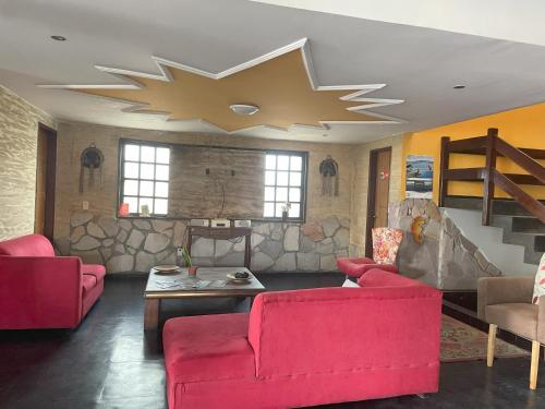 a living room with red couches and a star ceiling at Pousada Bedoya in Nísia Floresta