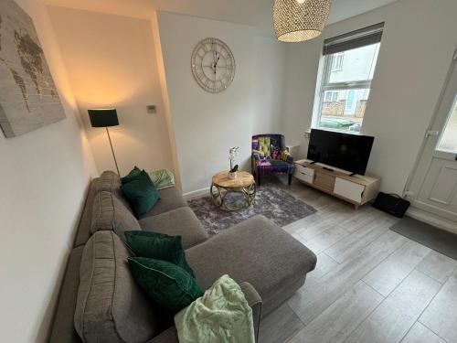 a living room with a couch and a tv at Star Road Home, central location, FREE parking in Peterborough