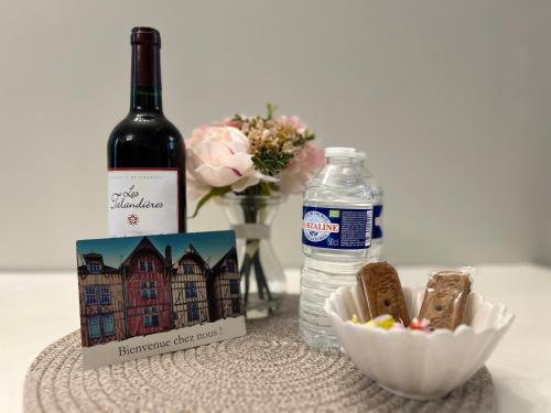- une bouteille de vin, un verre d'eau et une bouteille de vin dans l'établissement Cosy Vintage - Centre ville, à Troyes