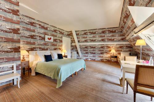 a bedroom with a bed and a brick wall at Château De La Bourdaisière in Montlouis-sur-Loire