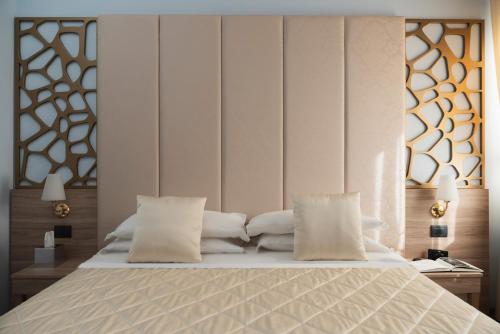 a bedroom with a bed with white sheets and pillows at Hotel Re Enzo in Bologna