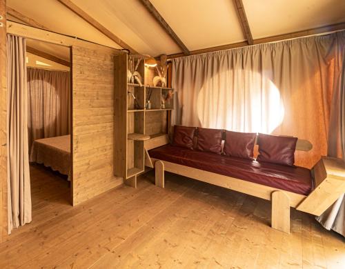 a couch in a room with a window at Delle Rose Camping & Glamping Village in Isolabona