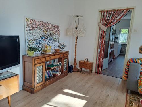 a living room with a tv and a couch at B&B Ut Kantuurke in Neer