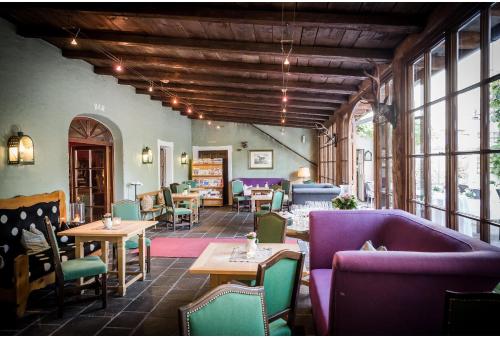 a restaurant with purple and green chairs and tables at Romantik Spa Hotel Elixhauser Wirt in Elixhausen