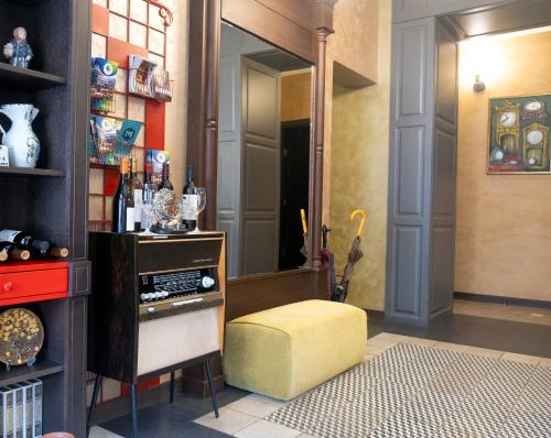 a room with a yellow ottoman and a mirror at Wine Story Hotel in Tbilisi City