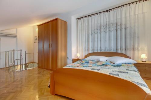 a bedroom with a large bed and a window at Apartments Franjo in Mali Lošinj