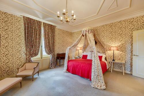 a bedroom with a red bed and a chandelier at Château De La Bourdaisière in Montlouis-sur-Loire