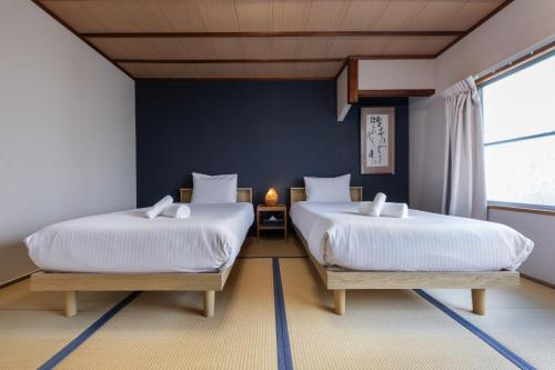 two beds in a room with blue walls at Shiki Homes HIKARI in Kyoto