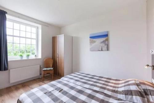 a bedroom with a bed and a window at Huis in de polder in Kamperland