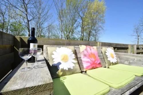 a picnic table with a bottle of wine and a glass at Huis in de polder in Kamperland