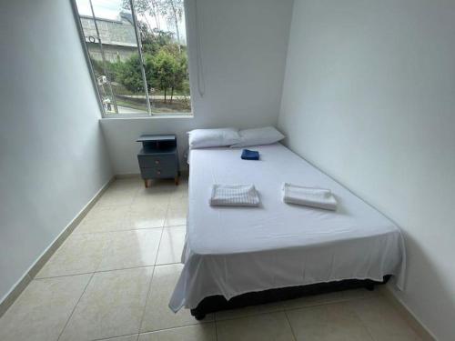 a bedroom with a bed and a window at apto san luis 407 in Armenia