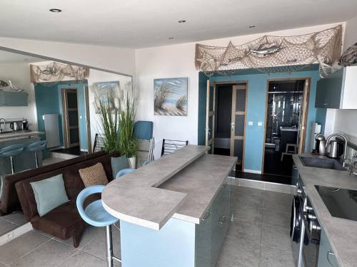 une cuisine avec un comptoir et un salon dans l'établissement Panoramique mer, T2 climatisé neuf avec stationnement à 200 m du village - FR-1-768-55, aux Issambres