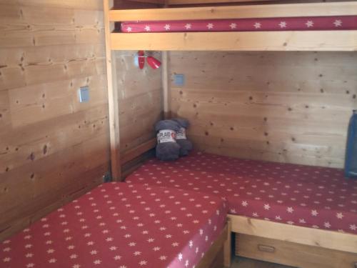 Cette petite chambre comprend un lit rouge dans une cabine. dans l'établissement Studio rénové 4/5 pers · Ski aux pieds - FR-1-181-1038, à Belle Plagne