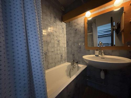 a bathroom with a sink and a bath tub and a sink at Studio cabine rénové, 4 couchages, pied des pistes, parking, balcon sud - FR-1-297-160 in Auris