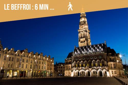 a large building with a clock tower at night at Au Puits Saint Josse - Centre Historique - WIFI in Arras