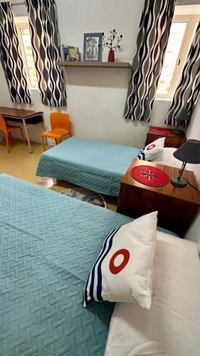 a bedroom with two beds and a table and chairs at Malta Crown guesthouse in St Julian's