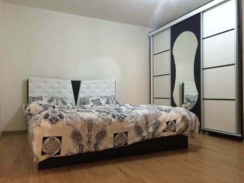 sypialnia z łóżkiem i dużym lustrem w obiekcie Taf's Small House w Prisztinie