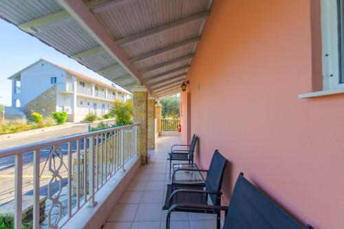 a balcony with chairs on a building at Spyridoula Resort in Corfu in Gouvia