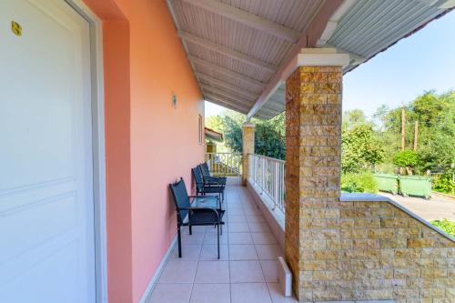 a covered porch with chairs on a house at Spyridoula Resort in Corfu in Gouvia