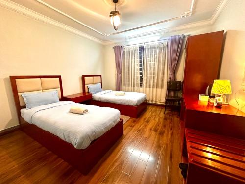 ein Hotelzimmer mit zwei Betten und einem Fenster in der Unterkunft Norbu Hotel in Kathmandu