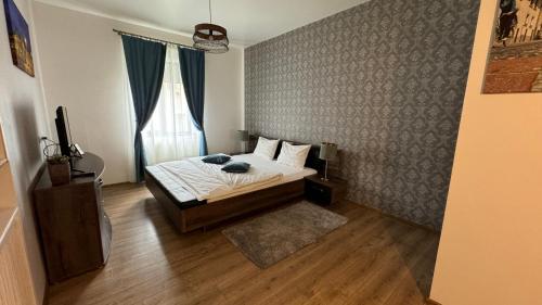 a bedroom with a bed and a wall with a window at DD Studio Deluxe in Sibiu