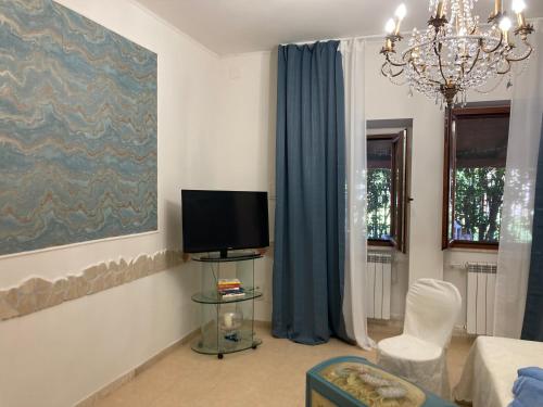 a living room with a tv and blue curtains at Il Giglio Viola in Ponte Lucano