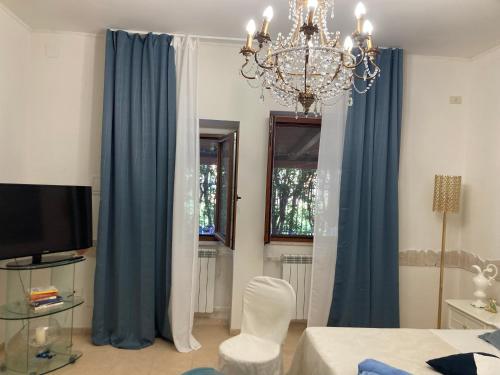 a living room with blue curtains and a chandelier at Il Giglio Viola in Ponte Lucano