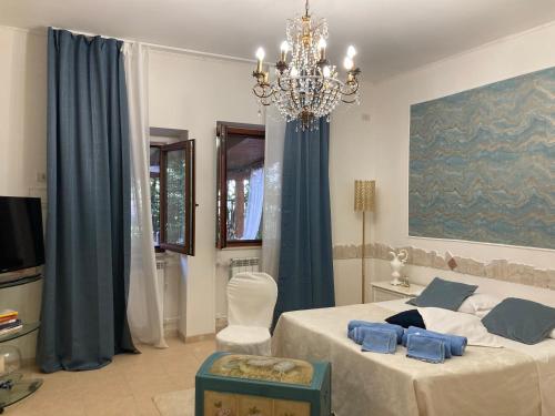 a bedroom with a large bed and a chandelier at Il Giglio Viola in Ponte Lucano