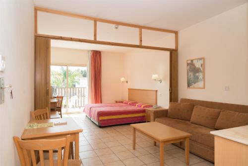 a living room with a couch and a bed at Tsokkos Paradise Holiday Village in Ayia Napa