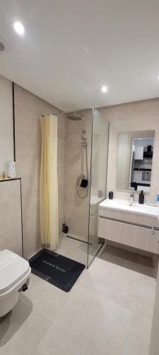 a bathroom with a shower and a toilet and a sink at Exclusive Apartment in Monastir