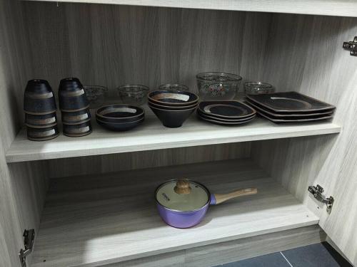 a shelf with bowls and plates and a bowl at Win & Sha's Homestay in Miri