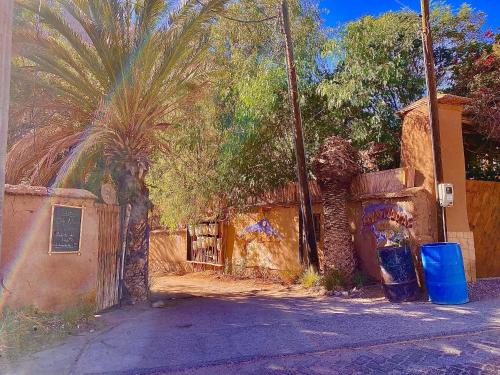 an old building with a fence and palm trees at La Casa entre los Árboles en el Valle de Elqui Montegrande in Paihuano