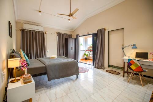 a bedroom with a bed and a desk with a computer at NomadGao Vila Nova - Comfort, Great Views, Fast WiFi & Interesting People in Anjuna