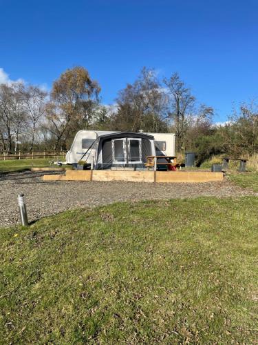 an rv parked in a field next to a grass field at Pantyronen tourer holidays in Llanbadarn-fynydd