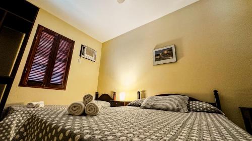 a bedroom with a bed with two towels on it at Pousada Villa Aman in Paraty