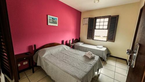 a room with two beds and a window at Pousada Villa Aman in Paraty