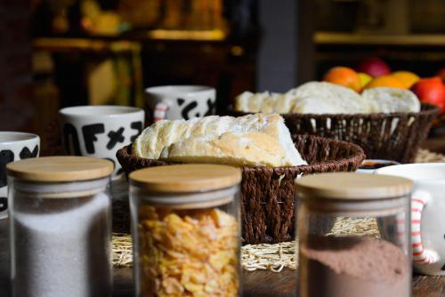 a table with jars of bread and baskets of fruit at Hostel Playa Pura Vida mdq in Mar del Plata