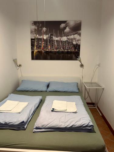 two beds in a room with a painting on the wall at Apartment Gabriella in Muggia
