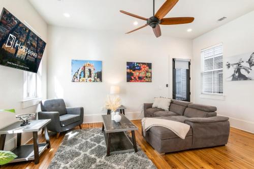 a living room with a couch and a ceiling fan at Private 3BR on Carondelet by Hosteeva in New Orleans