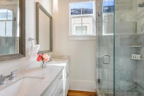 a bathroom with a sink and a glass shower at Fabulous Cottages with City Views in New Orleans