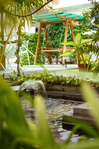 a playground in a garden with a pond at Thooru stay in Kelaa