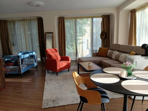 een woonkamer met een bank, een tafel en stoelen bij Cozy studio with FRENCH WINDOWS in Plovdiv