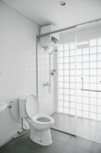 a white bathroom with a toilet and a shower at No303 in Bandung