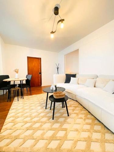 un salon avec un canapé blanc et une table dans l'établissement L'Élégance Royale, à Fontainebleau