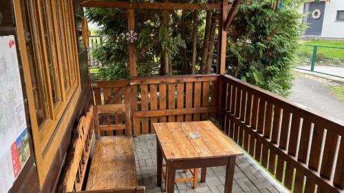 a wooden bench and a table on a porch at Drevenica u Porubäna in Jakubovany